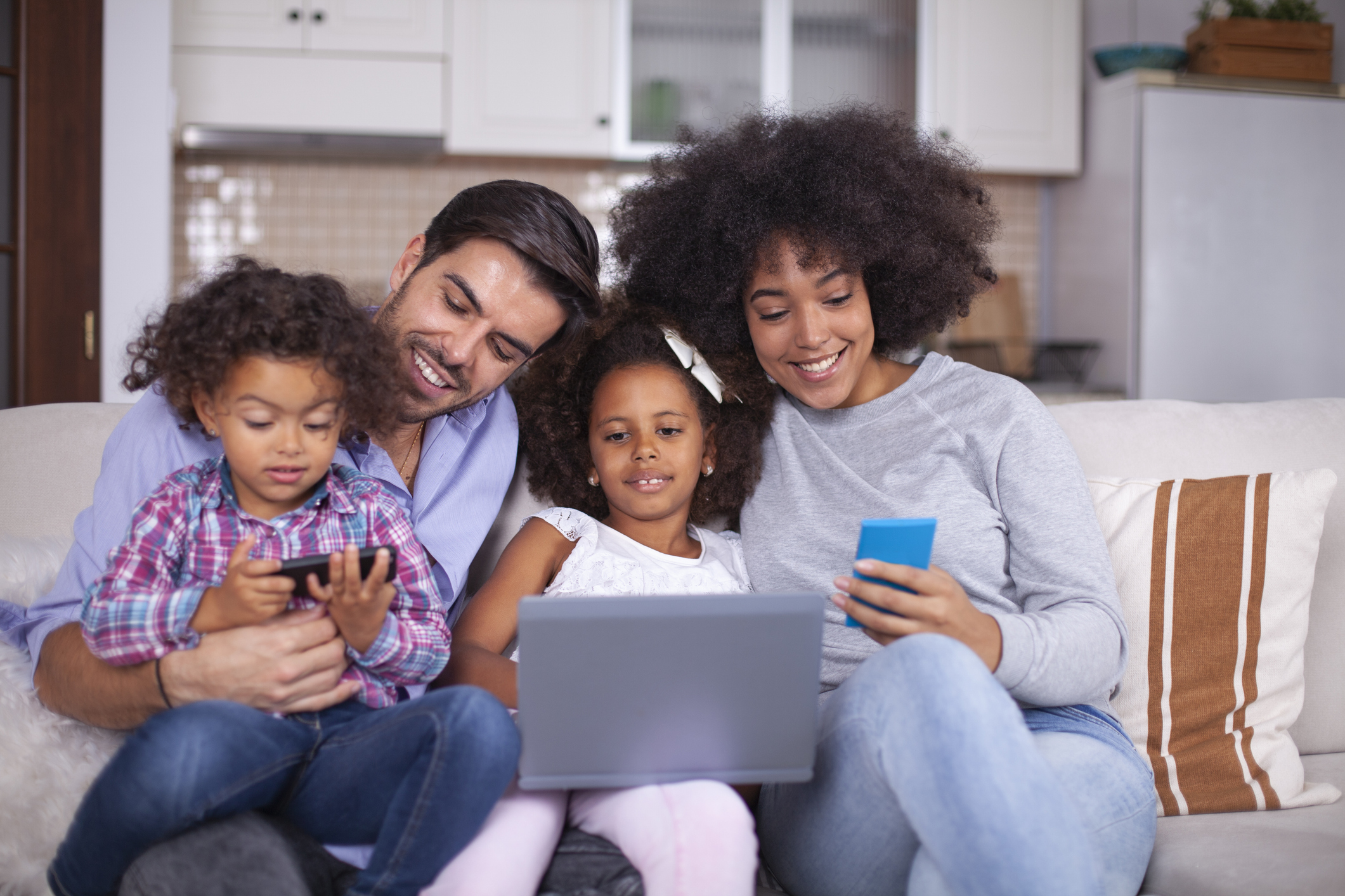 Happy family with little kids enjoying using laptop computer together